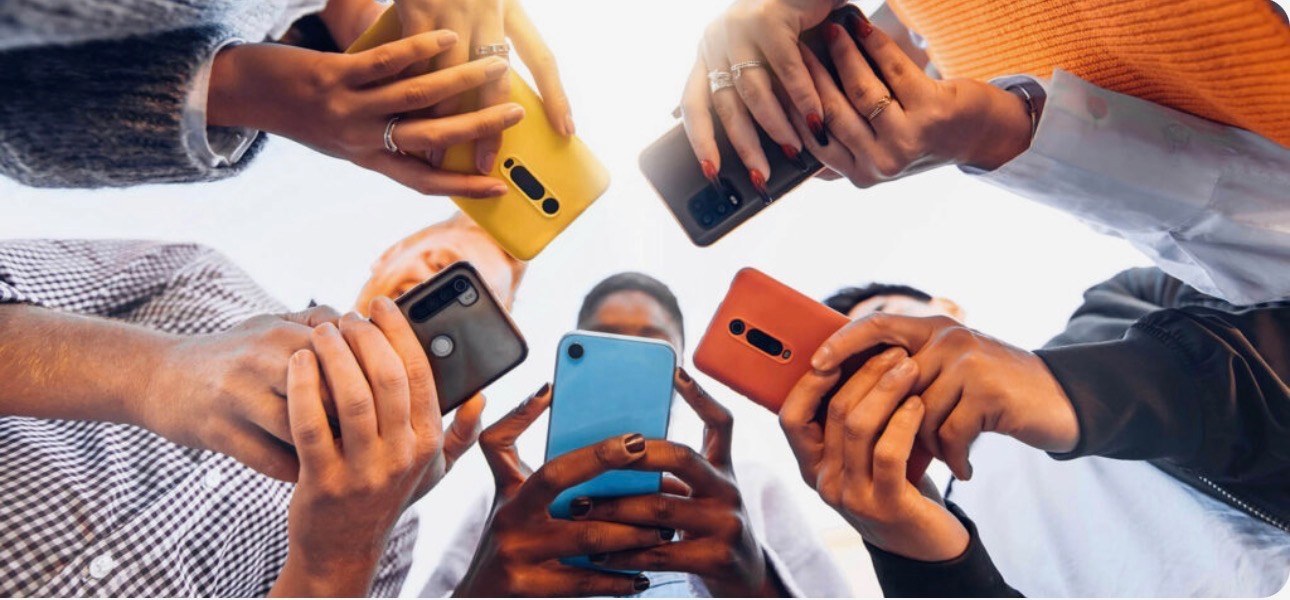 A group of people holding their phones together in a circle
